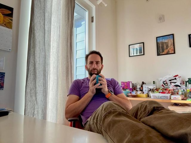 Paul starting at the camera with his feet up on his desk