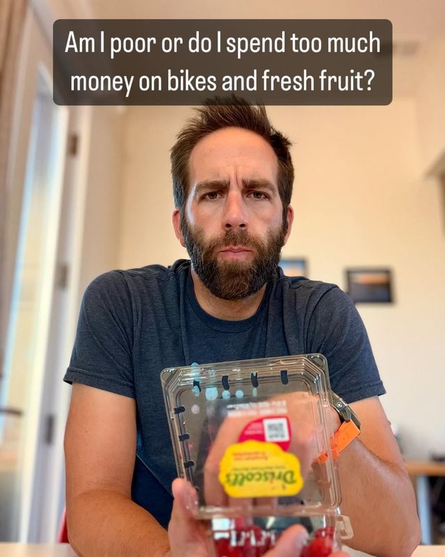 Paul staring at the camera while eating a half finished plastic container of raspberries