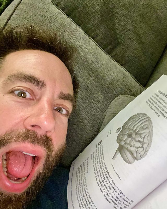 Up close photo with Paul and his Neuroscience textbook. Paul has an overly excited expression.